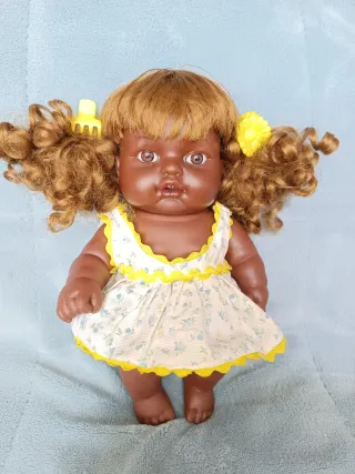 Muñeca negrita con 3 conjuntos de ropa