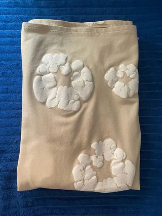 Camiseta corta beige con relieve blanco