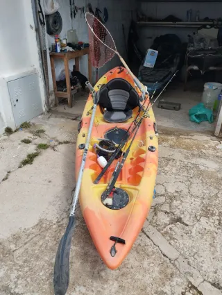 Piragua naranja y amarilla con accesorios