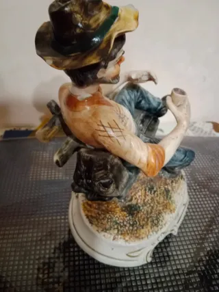 Soprammobile uomo seduto su staccionata in Capodim