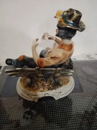 Soprammobile uomo seduto su staccionata in Capodim