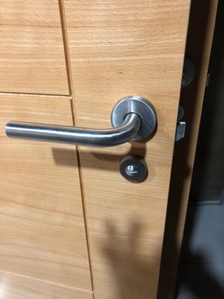 Puerta de madera clara con rejilla