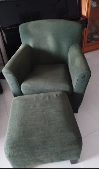 Butaca de tela verde con reposapiés