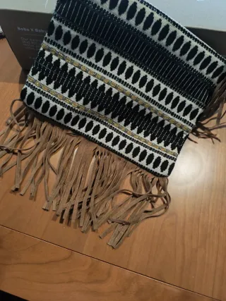 Bolso de mano con flecos.