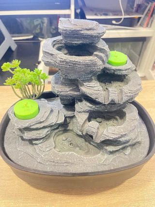 Fuente decorativa con velas y plantas
