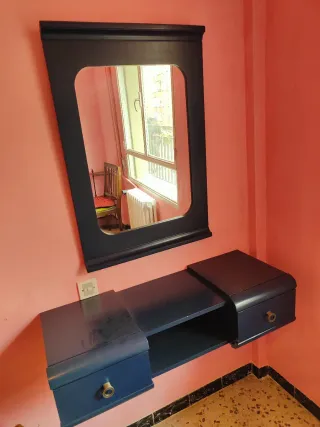 Mueble tocador azul oscuro con espejo.