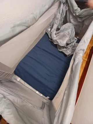 Cuna de viaje gris y móvil.