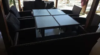 Sofá de mimbre con mesa de cristal