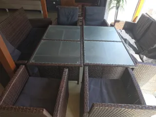 Sofá de mimbre con mesa de cristal