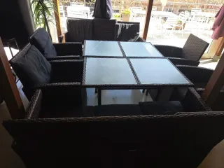 Sofá de mimbre con mesa de cristal