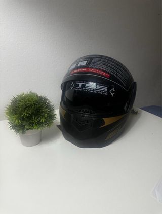 Casco de moto negro con detalles dorados