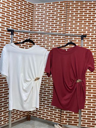 Camiseta blanca con broche dorado