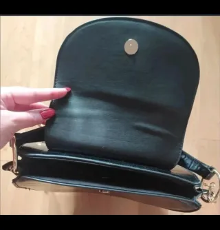 Bolso negro efecto cocodrilo con cadena dorada.