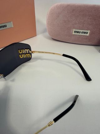 Gafas de sol Miu Miu negras y doradas