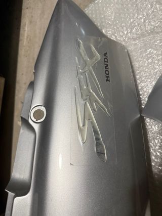Tapas laterales nuevas Honda SFX color gris plata.