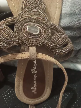 Sandálias Alma en Pena bege e douradas.