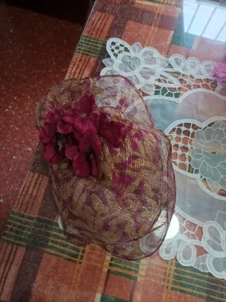 Tocado verde con flor y plumas rosas