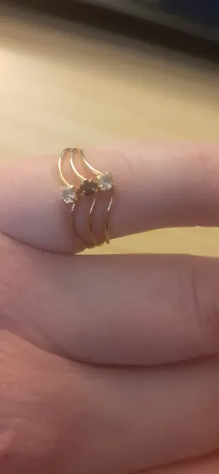 Anillo dorado calado con tres piedras brillantes