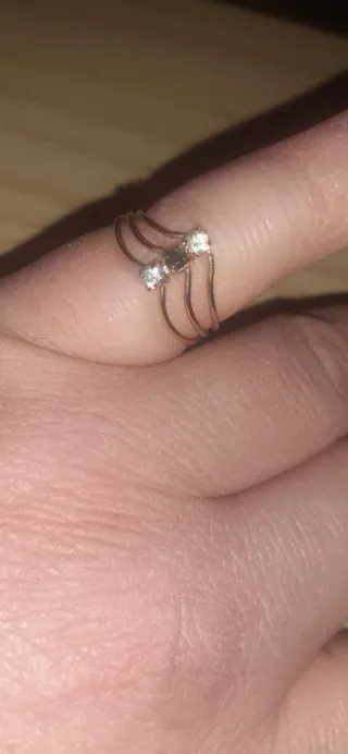 Anillo dorado calado con tres piedras brillantes