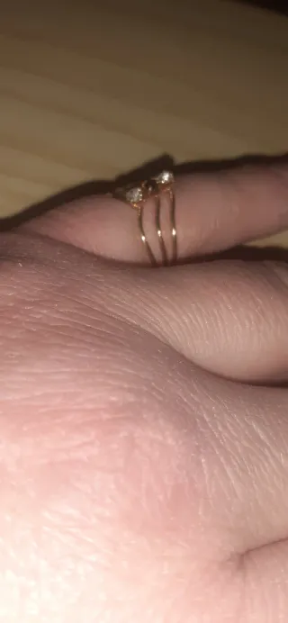 Anillo dorado calado con tres piedras brillantes