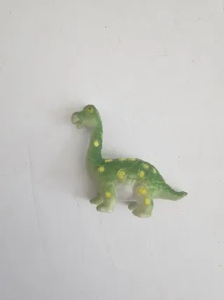 Dinosaurio miniatura verde con puntos amarillos