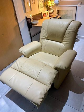 Sillón de masaje de piel color crema.