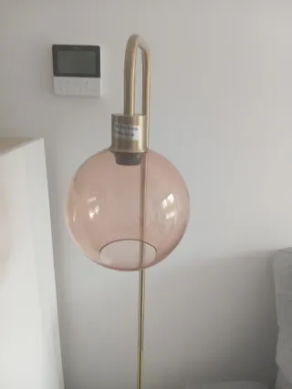 Lámpara de pie dorada con globo rosa