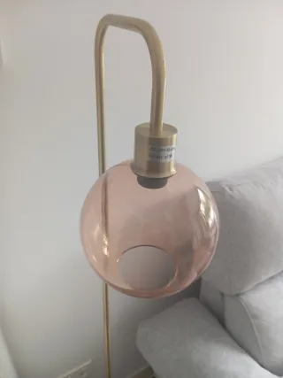 Lámpara de pie dorada con globo rosa