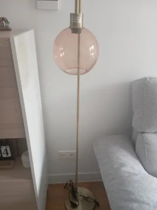 Lámpara de pie dorada con globo rosa
