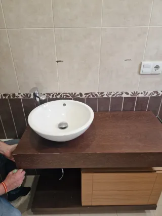 Mueble de baño de madera con lavabo y grifo