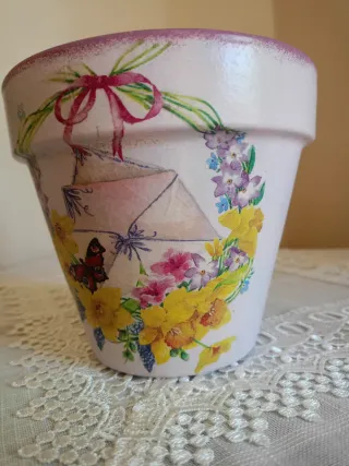 Vaso decorato con ghirlanda, fiori e farfalla