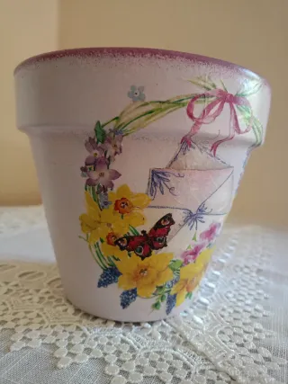 Vaso decorato con ghirlanda, fiori e farfalla