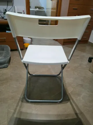 Silla plegable blanca y plateada