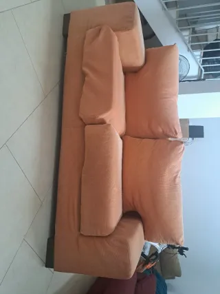Sofá de tela naranja, de dos puestos.