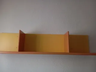 Dormitorio con cama, escritorio y estanterías.