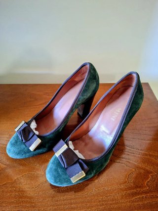 Zapatos de tacón verdes con lazo marrón.