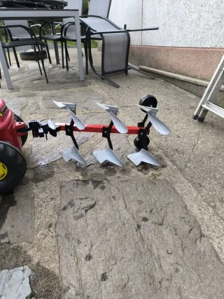 Tractor de pedales rojo con remolque