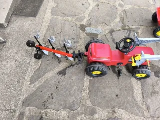 Tractor de pedales rojo con remolque