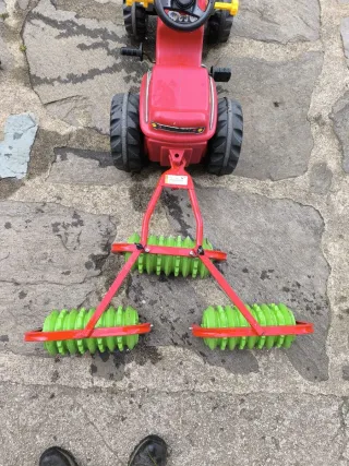 Tractor de pedales rojo con remolque