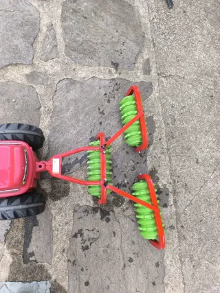 Tractor de pedales rojo con remolque