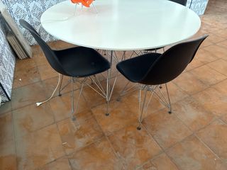 Mesa redonda de 120 blanca con 4 sillas negras.