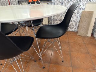 Mesa redonda de 120 blanca con 4 sillas negras.