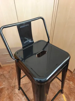 Taburete industrial SKLUM con respaldo.