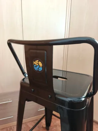 Taburete industrial SKLUM con respaldo.