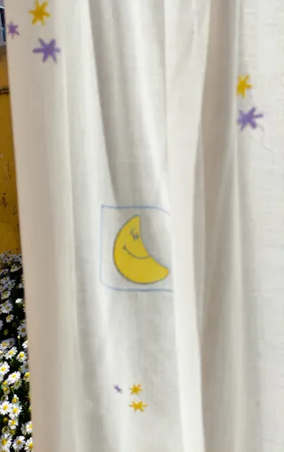 Cortina,  hecha, con lunas y estrellas, bordados.