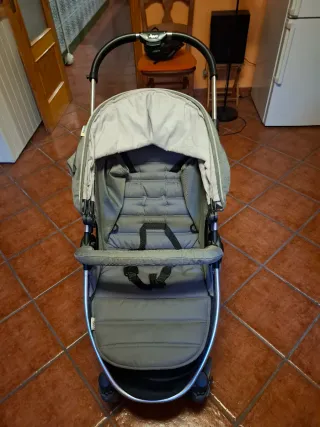 Cochecito de bebé gris plegable.
