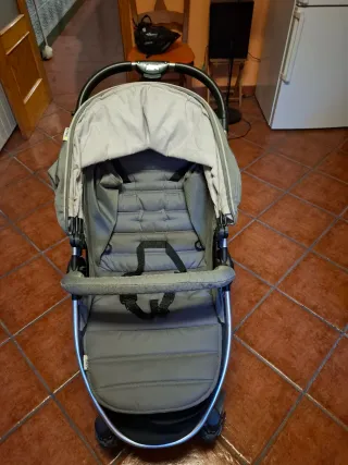 Cochecito de bebé gris plegable.