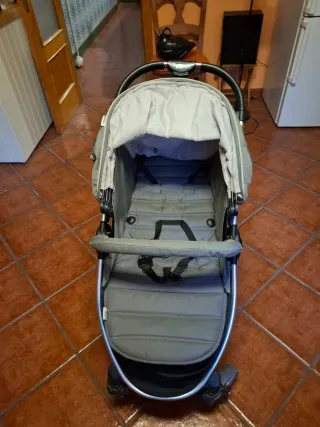 Cochecito de bebé gris plegable.