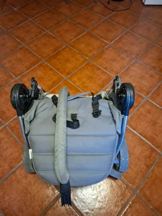 Cochecito de bebé gris plegable.