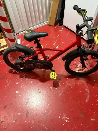 Bicicleta infantil roja con ruedines